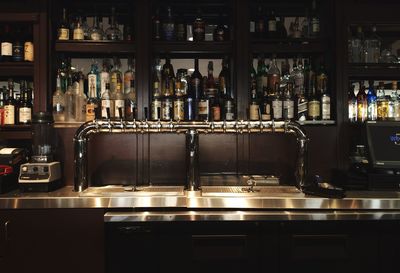 Liquor bottles arranged on bar shelves