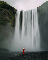 Rear view of man standing on waterfall