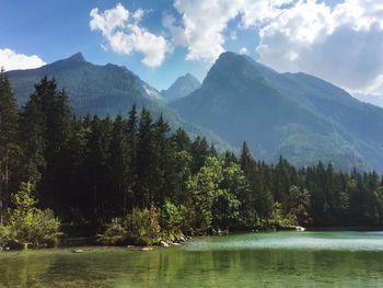 Scenic view of river and mountains against sky