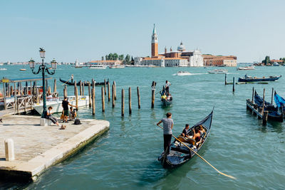 People traveling in boats on sea against church of san giorgio maggiore