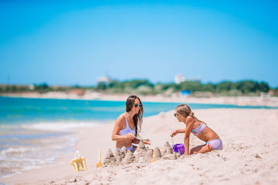 People on beach against clear sky