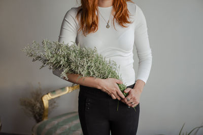 Midsection of woman holding plant