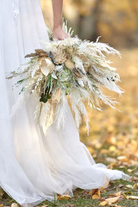 Midsection of woman holding flower