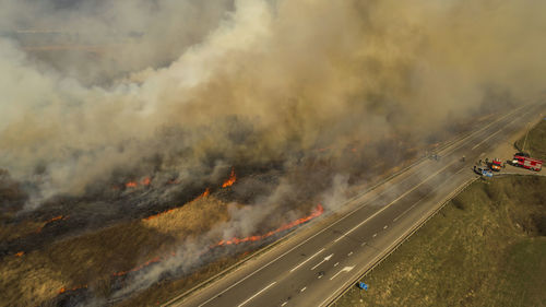 Massive fire, dry grass lanes in fire, firefighters at work, disaster, ecological catastrophe