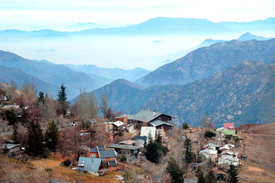 Houses by mountains against sky