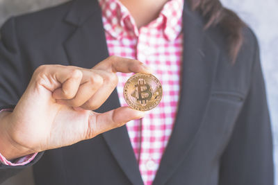 Cropped hands of business person holding bitcoin