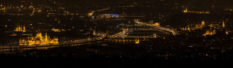 Panoramic view of illuminated parliament building and bridge at night