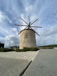 Traditional windmill on road against sky