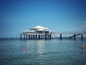 Built structure in sea against blue sky