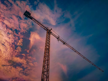 Low angle view of crane against sky during sunset