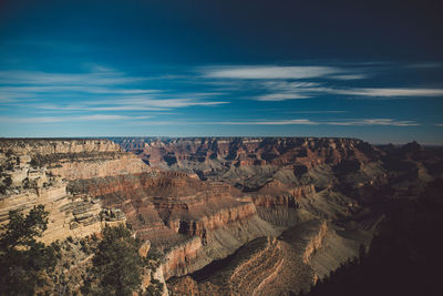 Scenic view of eroded landscape against blue sky