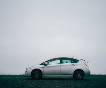 Vintage car on field against sky