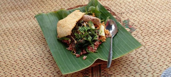 Pecel ndeso, indonesian traditional food served on a plate covered with banana leaves