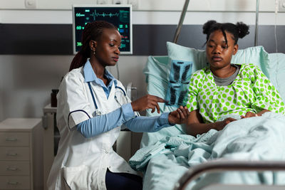 Doctor showing medical x-ray to patient in hospital