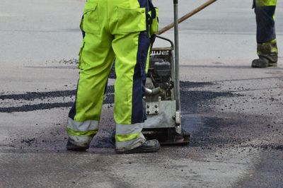 Low section of man working on road