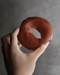 Close-up of cropped hand holding donut