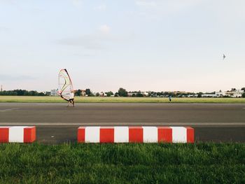 Rear view of man skating with windsurfing board on street