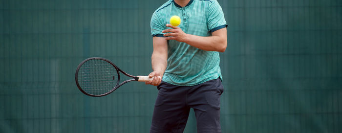 Midsection of athlete playing tennis in court