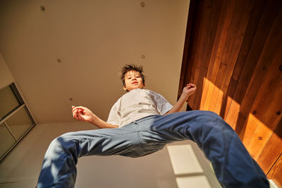 Asian boy jumping cheerfully on the bed.