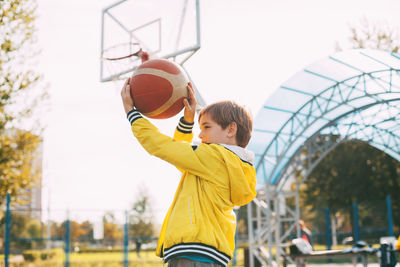 Boy playing with basketball in court