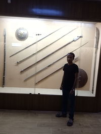 Full length portrait of young man standing against wall