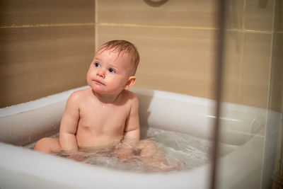 Cute boy sitting in bath