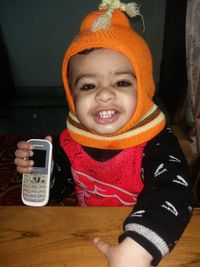 Portrait of smiling girl holding smart phone in winter