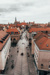 High angle view of people on footpath amidst buildings in town