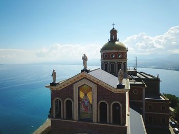 View of building by sea against sky