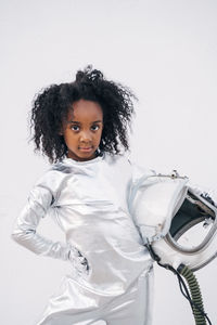 Portrait of little girl with space hat wearing space suit in front of white background