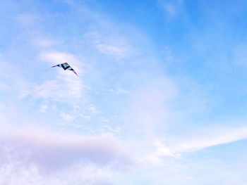 Low angle view of airplane flying against blue sky