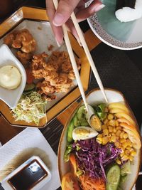 Close-up of hand holding food served on table