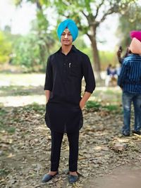 Portrait of smiling man wearing turban standing on land