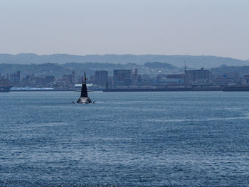 Scenic view of sea with submarine against clear sky