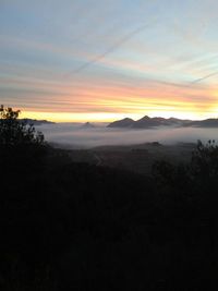 Scenic view of silhouette mountains against sky during sunset