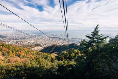 Overhead cable car on landscape against sky