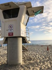 Lifeguard hut on beach against sky