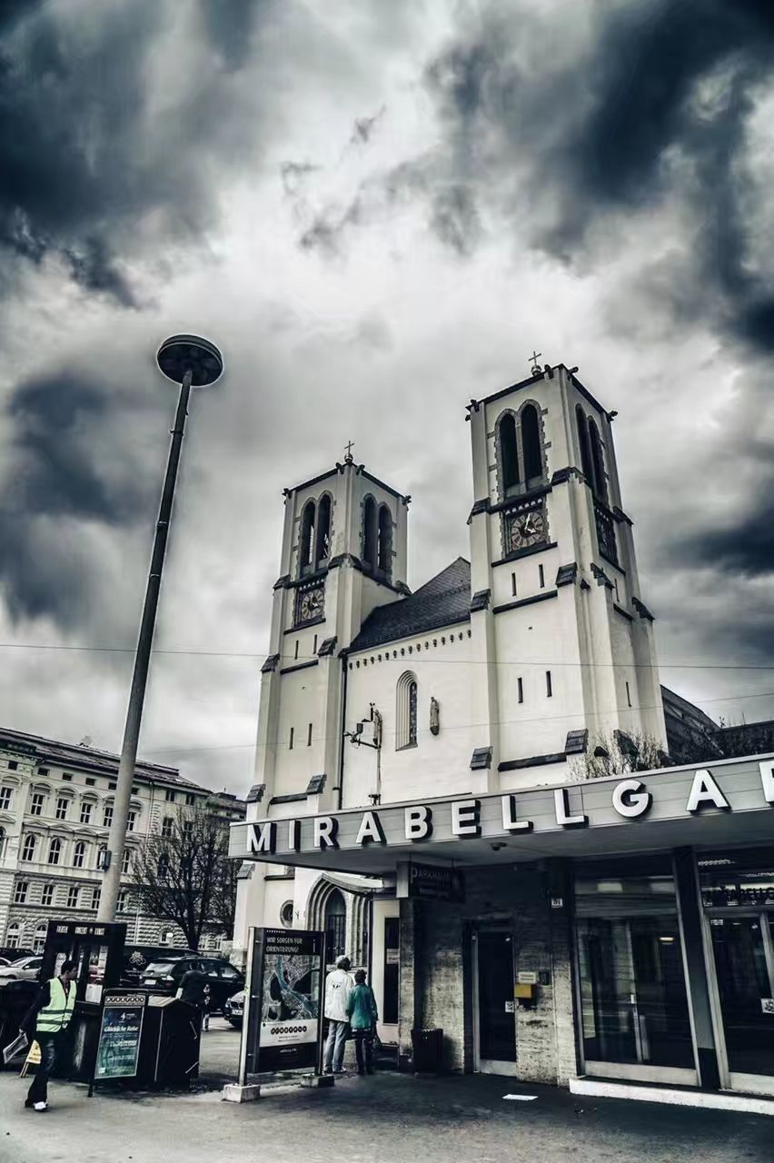 cloud - sky, sky, building exterior, architecture, built structure, low angle view, city, street, nature, day, building, outdoors, incidental people, overcast, street light, transportation, history, sign