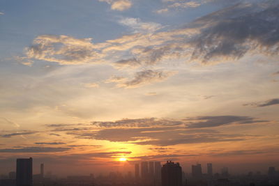 View of cityscape against cloudy sky during sunset