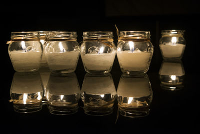 Close-up of lit candles in shelf