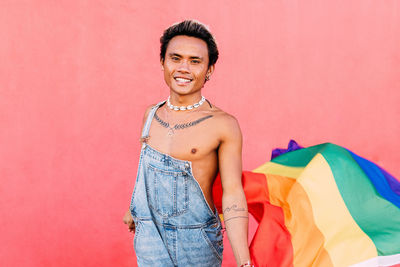 Portrait of gay man against wall