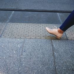 Low section of person standing on footpath