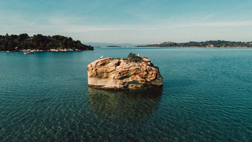 Rock formation in sea against sky