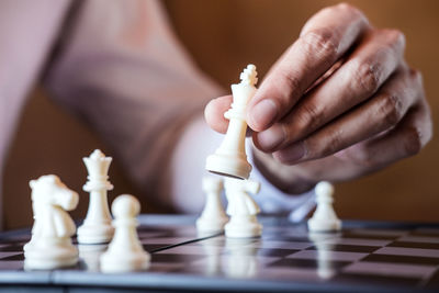 Cropped hand of man playing chess at table