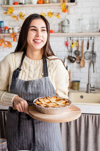 Portrait of young woman having food on table