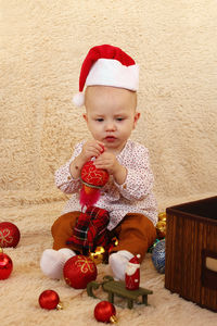 High angle view of cute girl playing with christmas tree at home