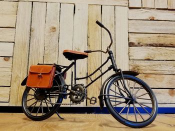 Bicycle parked on footpath against wall