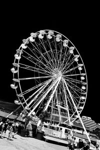 Low angle view of illuminated ferris wheel against sky at night