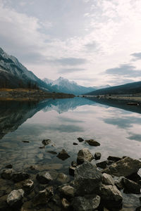 Scenic view of lake by mountains against sky