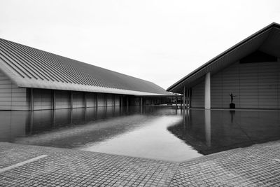 Building by water against clear sky